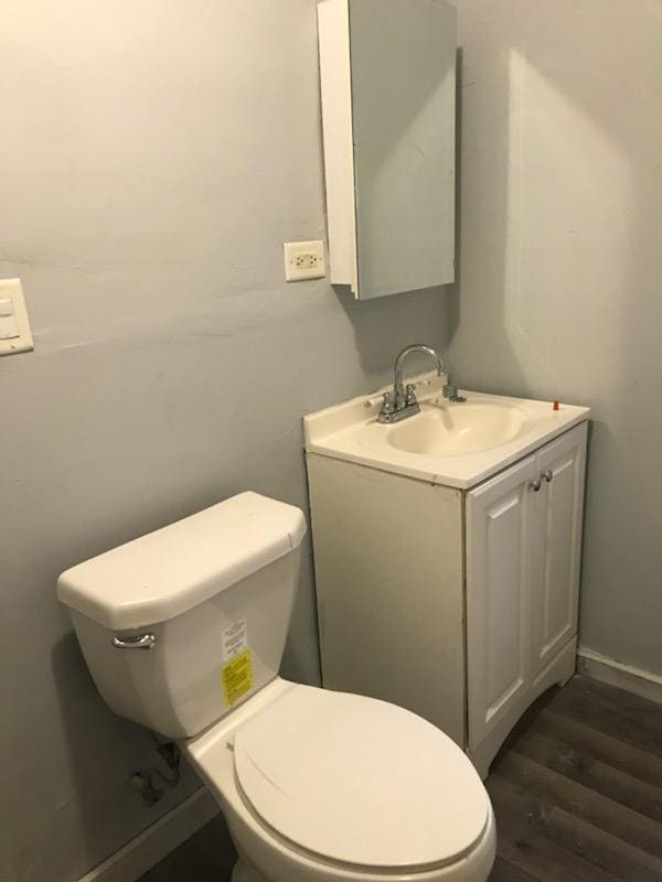 bathroom featuring vanity, hardwood / wood-style floors, and toilet