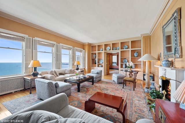 living room featuring crown molding, a water view, and light hardwood / wood-style floors