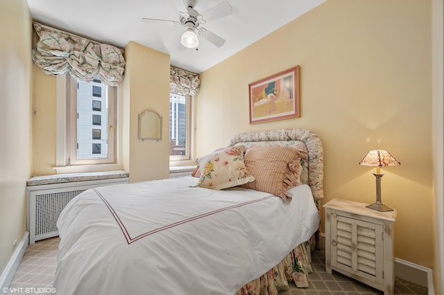 carpeted bedroom with ceiling fan and radiator heating unit