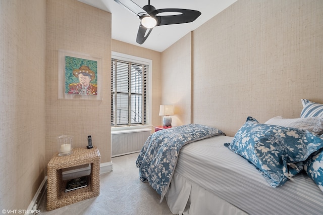 bedroom with ceiling fan, light carpet, and radiator