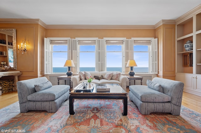 living room featuring built in features, a healthy amount of sunlight, ornamental molding, and wood-type flooring