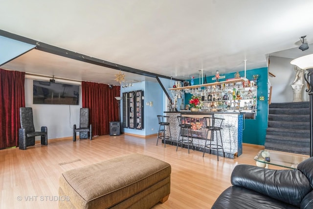 living room with bar and wood-type flooring