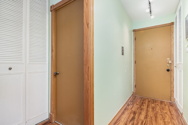 hall featuring dark hardwood / wood-style flooring and rail lighting