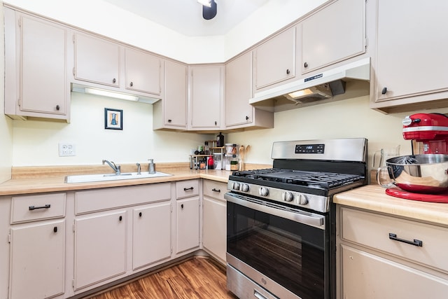 kitchen with white cabinets, sink, light hardwood / wood-style floors, and stainless steel gas range