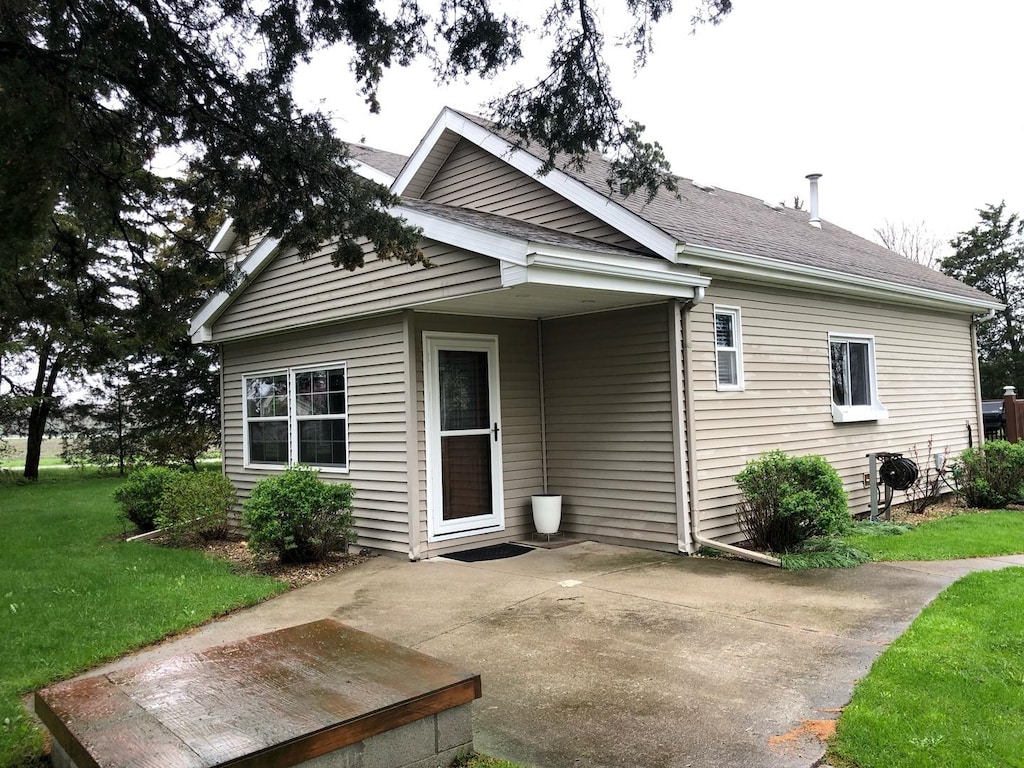 back of house with a patio area and a lawn