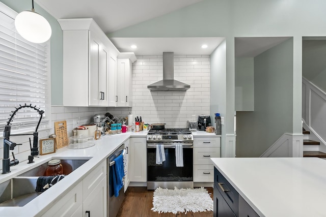 kitchen featuring pendant lighting, tasteful backsplash, stainless steel appliances, white cabinetry, and wall chimney exhaust hood