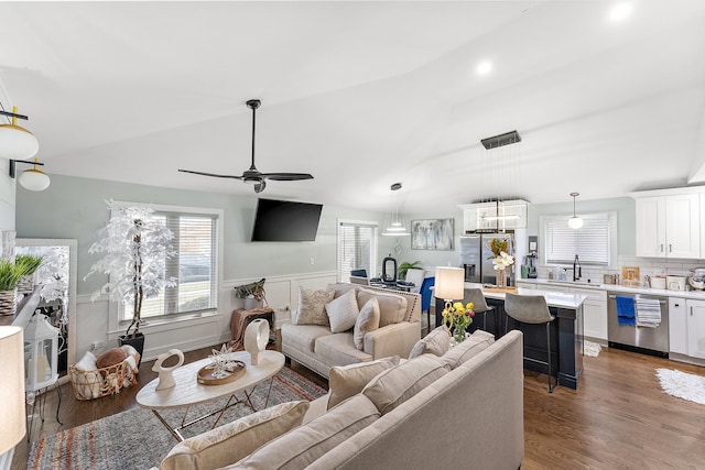 living room featuring ceiling fan, sink, dark wood-type flooring, and vaulted ceiling