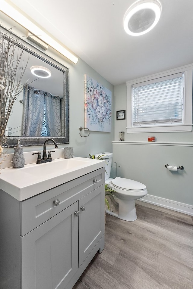 bathroom with hardwood / wood-style floors, oversized vanity, and toilet