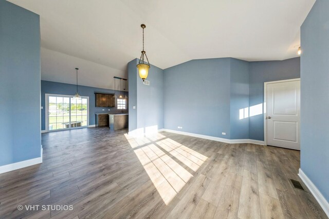 unfurnished living room with wood-type flooring and vaulted ceiling