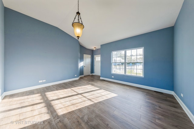 spare room with lofted ceiling and hardwood / wood-style flooring