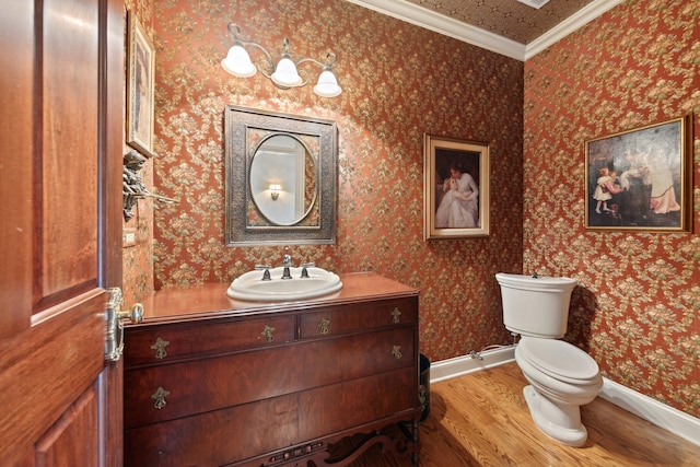 bathroom with vanity, toilet, hardwood / wood-style flooring, and ornamental molding