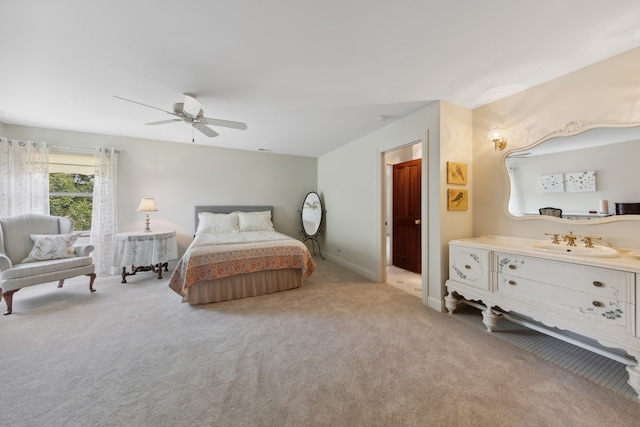 carpeted bedroom featuring ceiling fan and sink