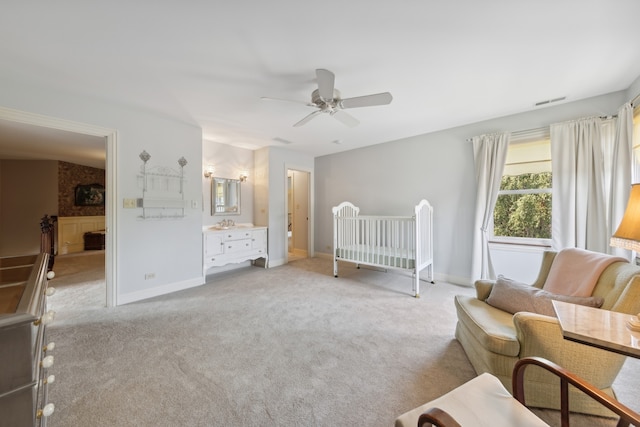 unfurnished bedroom with brick wall, light colored carpet, a crib, and ceiling fan