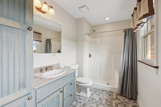 bathroom with a wealth of natural light, a shower with curtain, tile flooring, toilet, and vanity