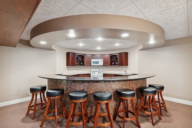 bar featuring white appliances, a paneled ceiling, carpet, and sink