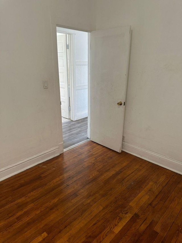 empty room with baseboards and hardwood / wood-style floors