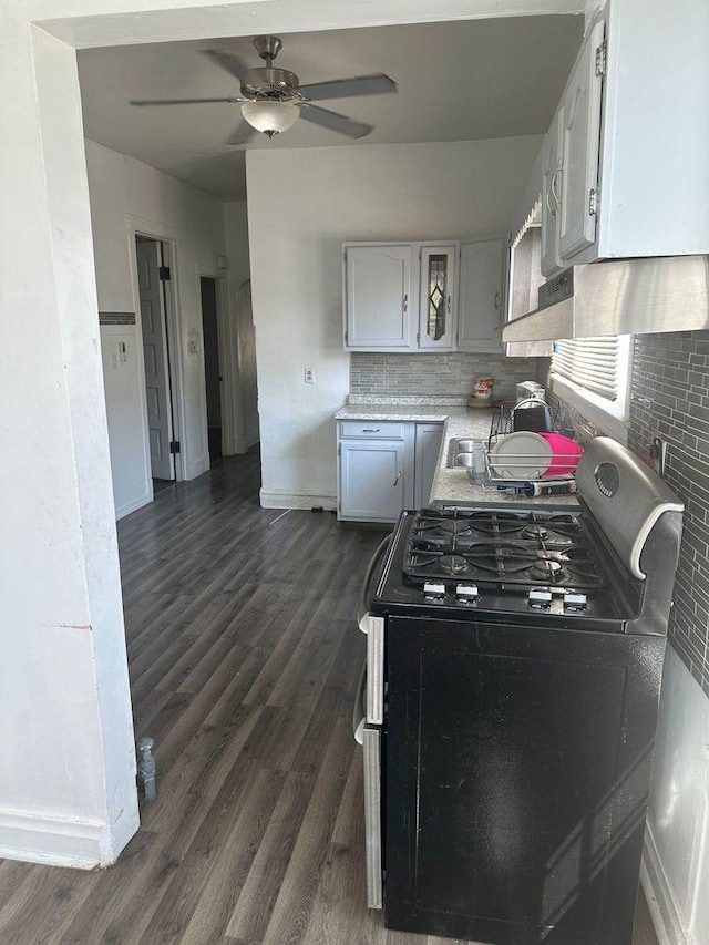 kitchen with range with gas stovetop, dark wood-style flooring, light countertops, backsplash, and a ceiling fan