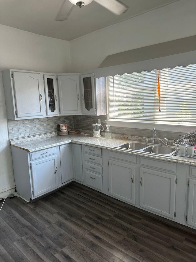 kitchen with dark wood-style floors, white cabinetry, a sink, and decorative backsplash