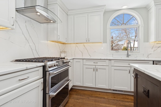 kitchen with white cabinets, range hood, and range with two ovens