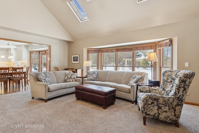 carpeted living room featuring plenty of natural light, high vaulted ceiling, and a skylight