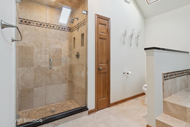 bathroom with an enclosed shower, toilet, tile patterned floors, and vaulted ceiling with skylight