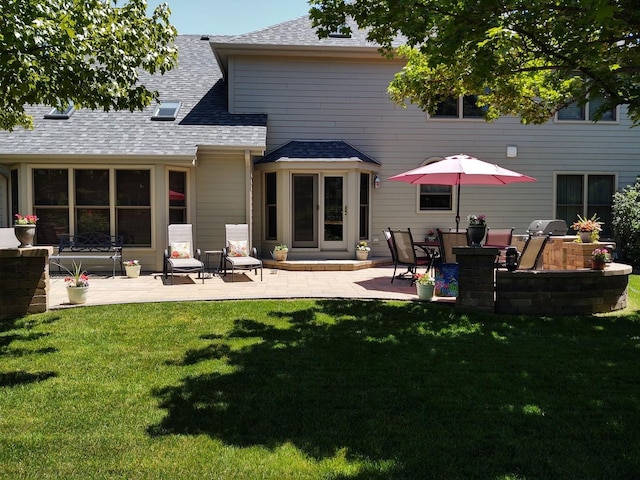 rear view of property with a yard and a patio area