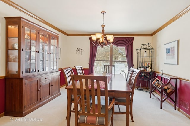 carpeted dining space with crown molding and a notable chandelier