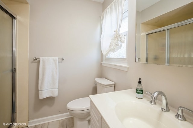 bathroom with vanity, toilet, and a shower with shower door