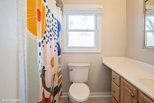 bathroom with tile patterned floors, vanity, toilet, and walk in shower