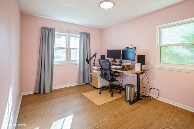 home office with plenty of natural light and light hardwood / wood-style floors