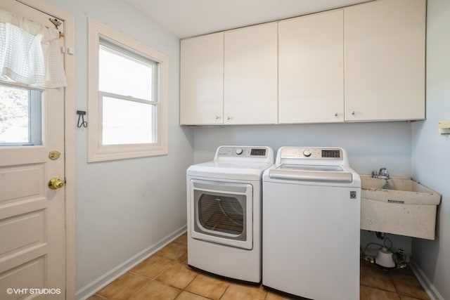 washroom featuring cabinets, light tile patterned floors, washer and clothes dryer, and sink