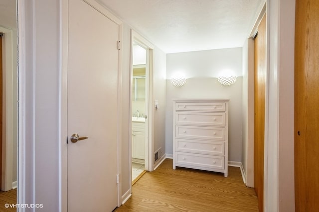 corridor featuring light hardwood / wood-style flooring and sink