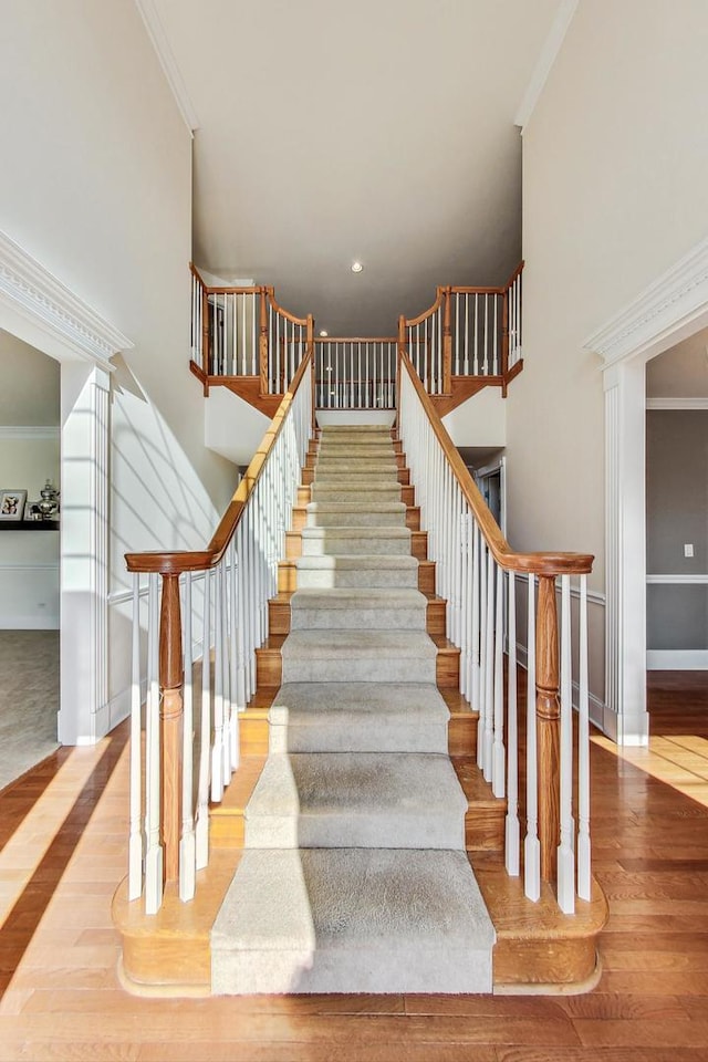 stairway featuring hardwood / wood-style flooring and ornamental molding