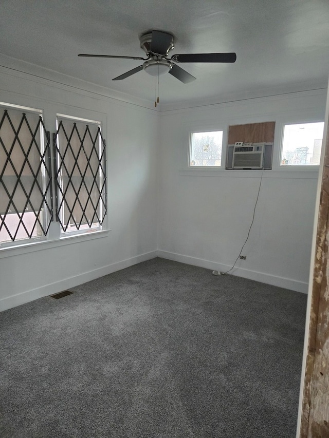 carpeted empty room featuring ceiling fan and a wealth of natural light