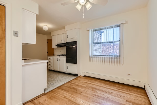 kitchen featuring white cabinets, a baseboard radiator, light hardwood / wood-style flooring, black appliances, and ceiling fan