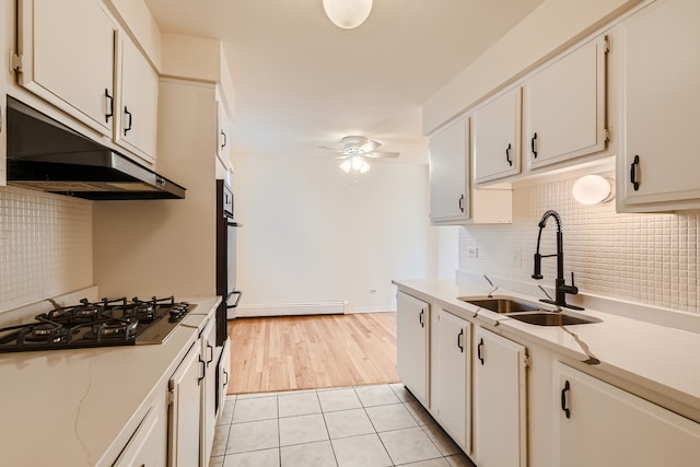 kitchen featuring ceiling fan, light tile floors, sink, backsplash, and white cabinetry