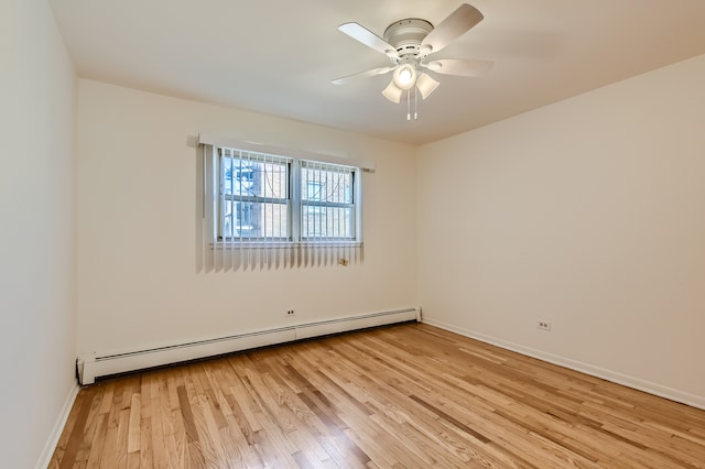 empty room with ceiling fan, a baseboard heating unit, and light hardwood / wood-style floors