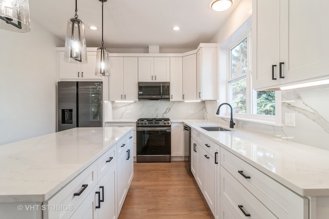 kitchen featuring backsplash, light hardwood / wood-style flooring, stainless steel appliances, sink, and a center island