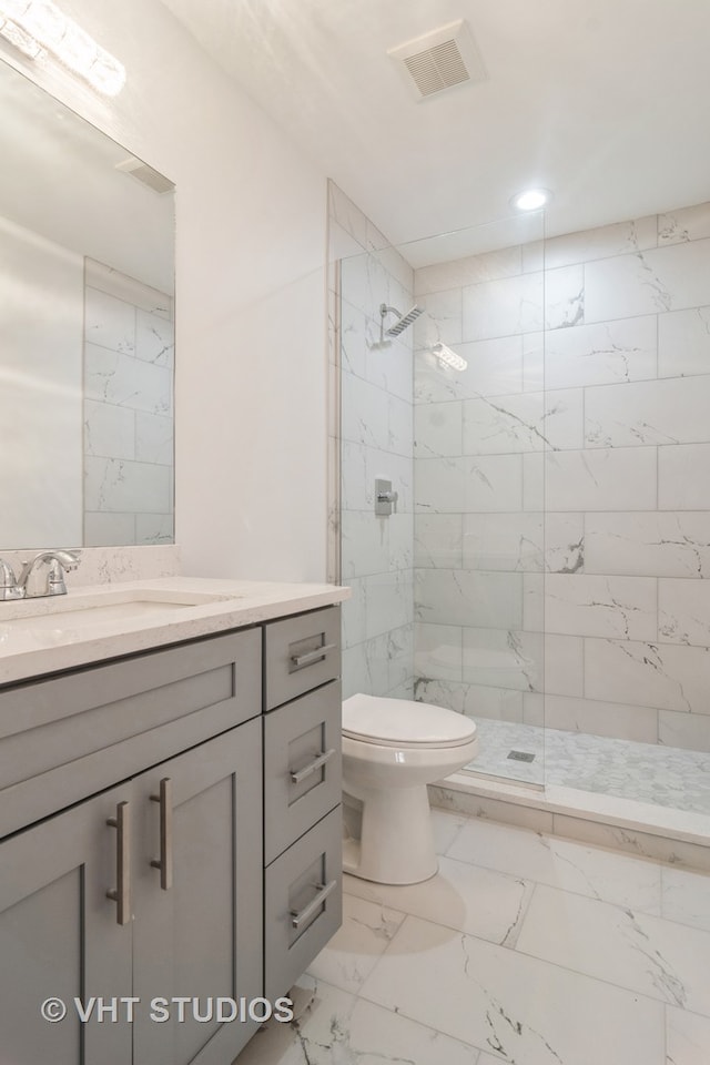 bathroom with a shower with door, toilet, tile flooring, and vanity