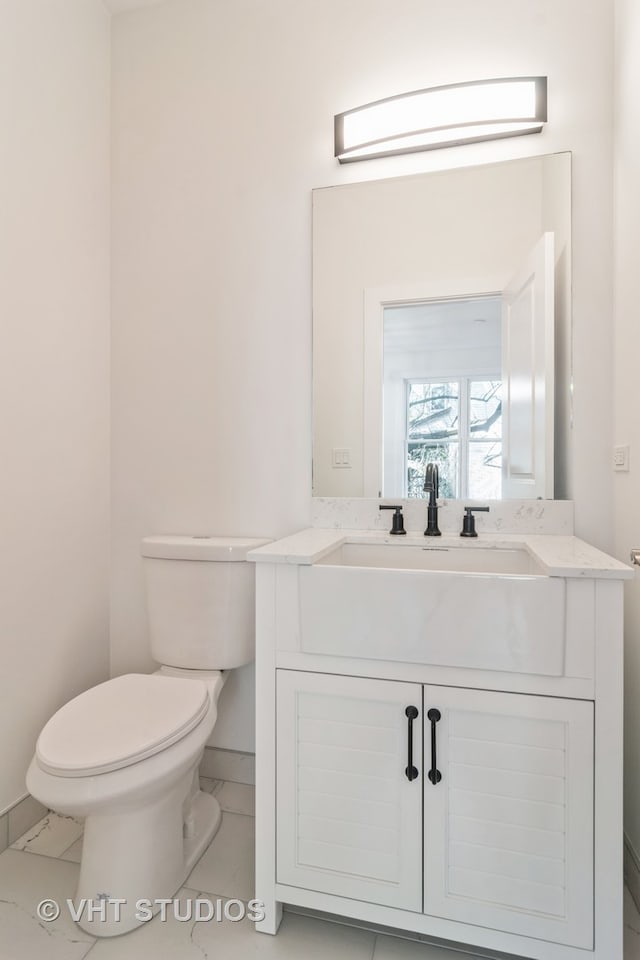 bathroom featuring vanity, tile floors, and toilet