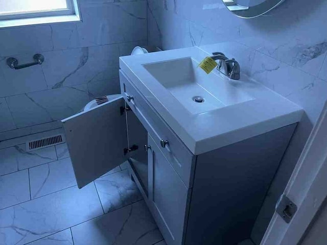 bathroom featuring tile walls, tile floors, and vanity