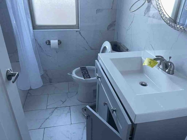 bathroom with tile walls, toilet, tile floors, and vanity