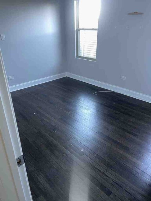 unfurnished room featuring dark wood-type flooring