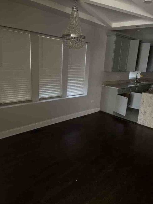 unfurnished dining area with sink and a notable chandelier