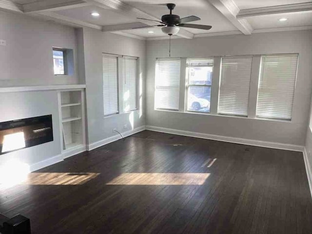 unfurnished living room with coffered ceiling, dark hardwood / wood-style floors, ceiling fan, and a wealth of natural light