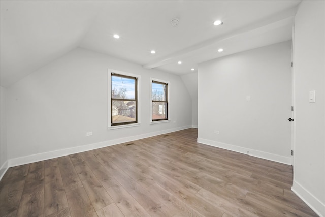 spare room featuring hardwood / wood-style flooring and vaulted ceiling