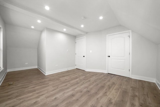 bonus room with vaulted ceiling and dark wood-type flooring