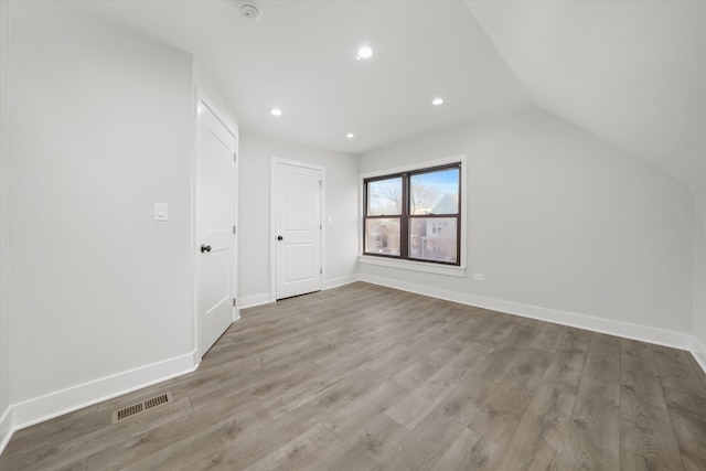 bonus room with lofted ceiling and hardwood / wood-style flooring