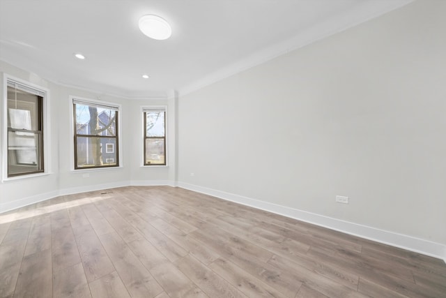 spare room with light hardwood / wood-style floors and ornamental molding