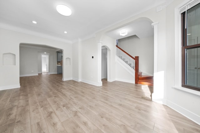 unfurnished living room with light wood-type flooring and ornamental molding